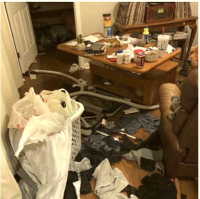 Living room cluttered with laundry and items on the coffee table